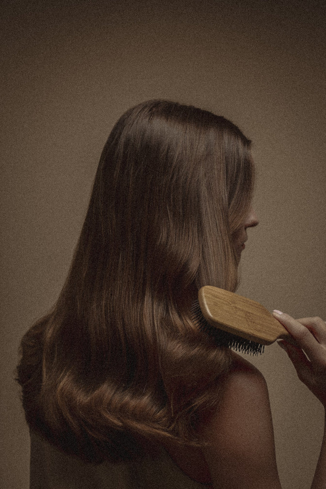 Lange, glänzende Haare werden mit Bürste gekämmt – gesundes Haar dank Keratin-Pflege ohne Haarbruch